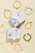 bracelet variations made by petit moi scattered across a white background. along with the box it comes with