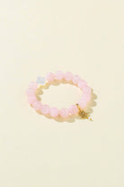 pink pearl bracelet made by petit moi. placed on a white table 