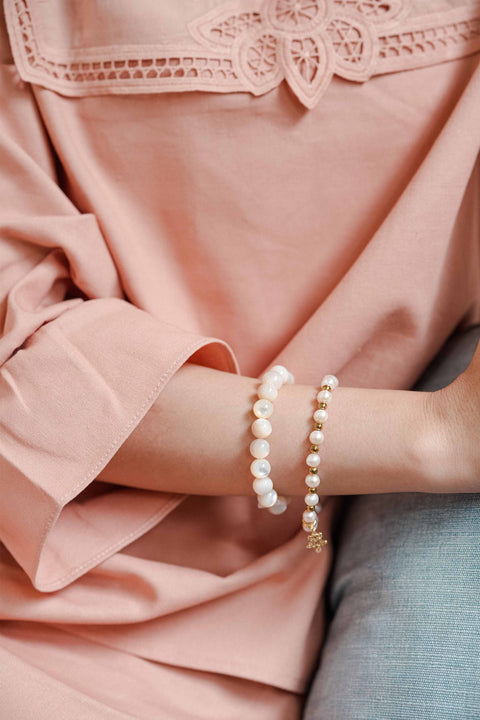 Female model wearing high quality pink baju kurung and bracelets made by petit moi