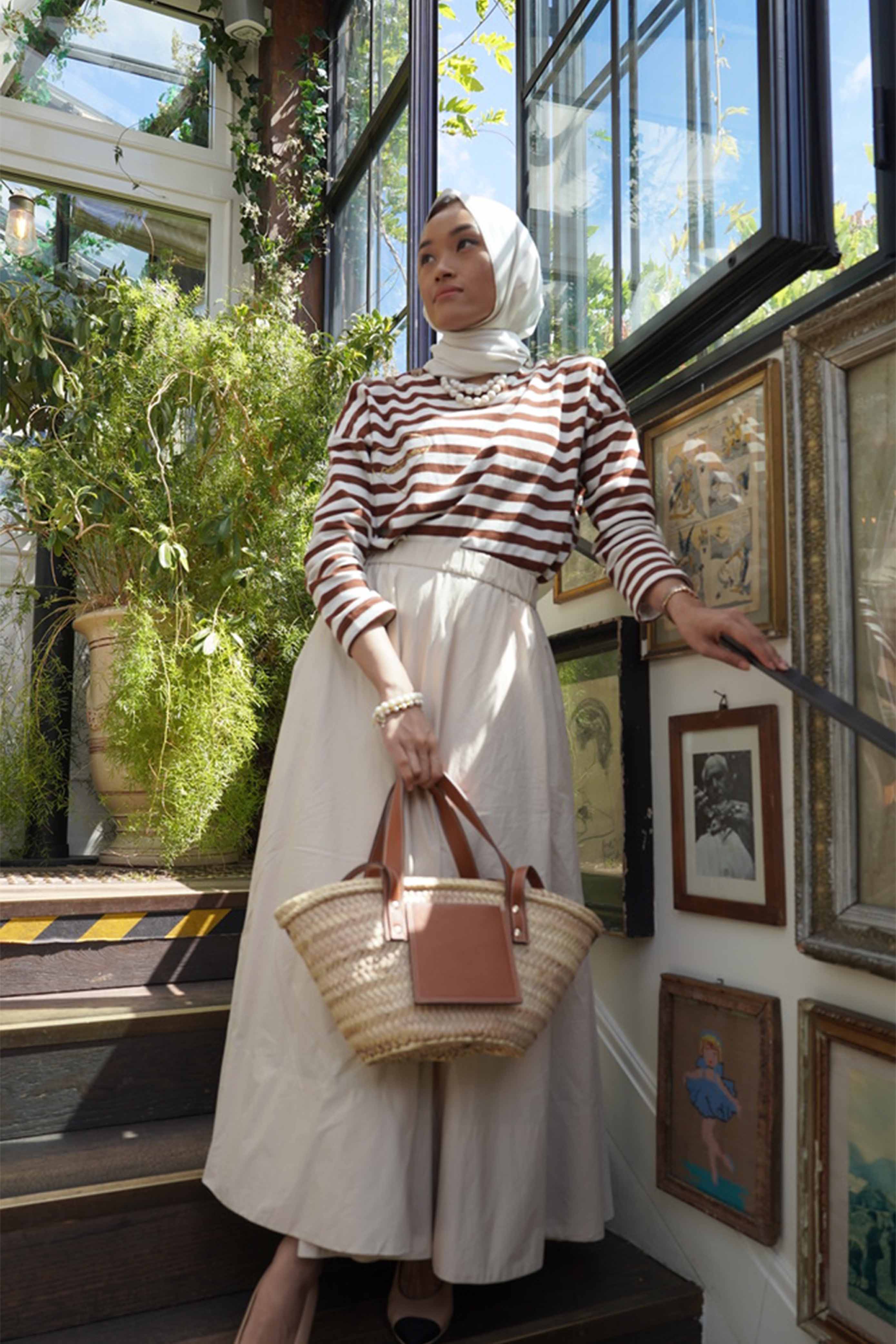 Female model in paris wearing a striped brown blouse and brown skirt made by petit moi