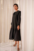 female model posing in black dress made by petit moi