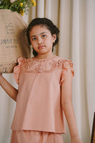 Little girl posing for the camera in high quality modest clothes made by petit moi