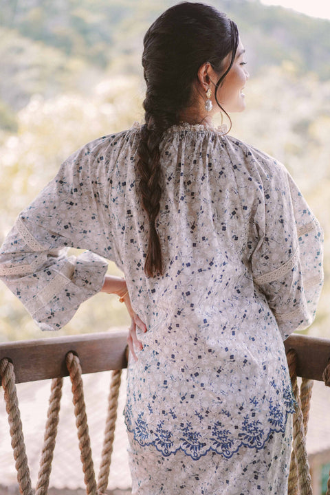 Back shot of female model wearing blue floral baju kurung