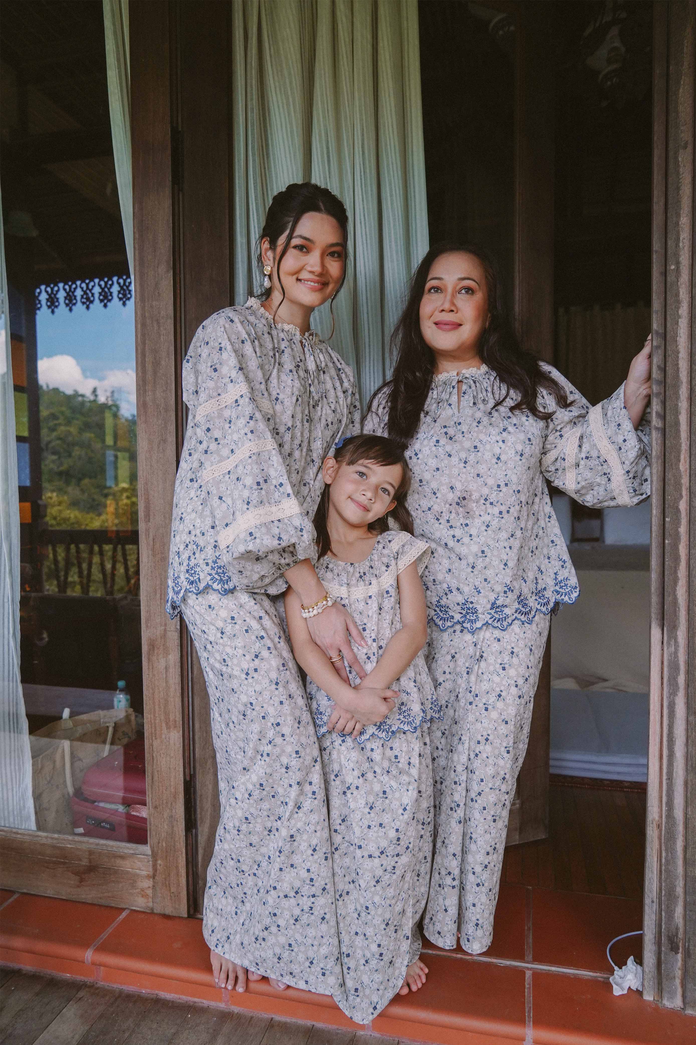 Mother and her daughters wearing matching blue floral baju kurung by petit moi