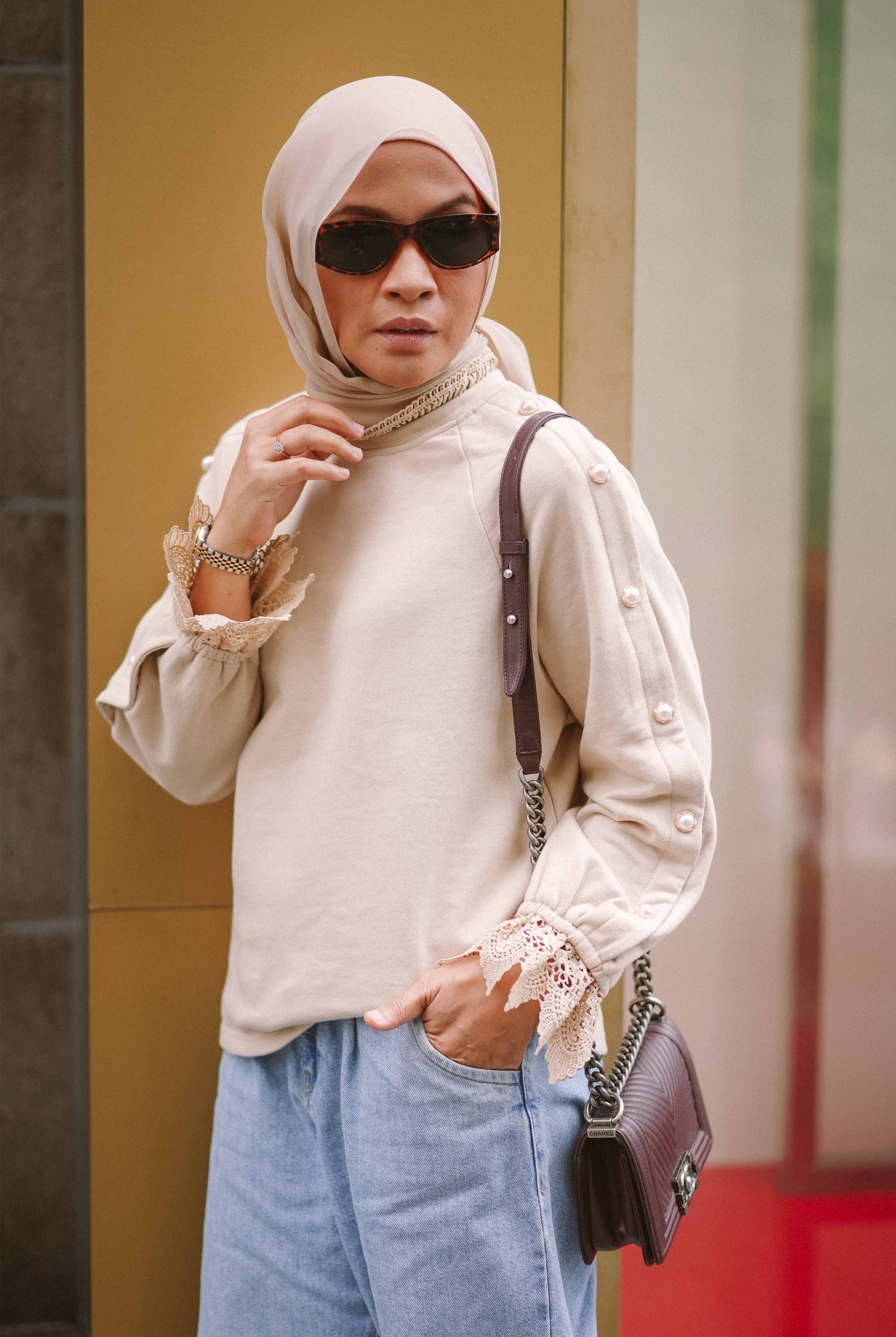 Female elderly model posing in beige jumper designed by petit moi