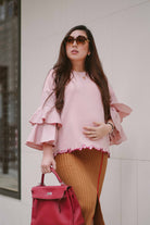 pregnant mother wearing a pink blouse by petit moi