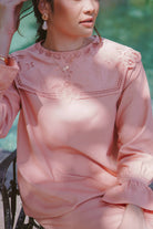Closeup shot of dress worn by female model sitting down at the pool and posing for the camera