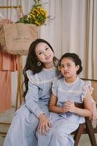 two sisters wearing matching baju kurung designed by petit moi