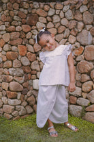 Little girl posing in her favourite light blue dress made by petit moi