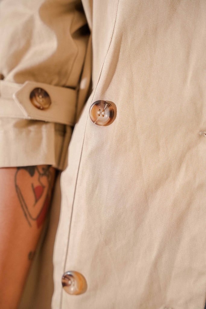 close up shot of high quality trench coat designed by petit moi