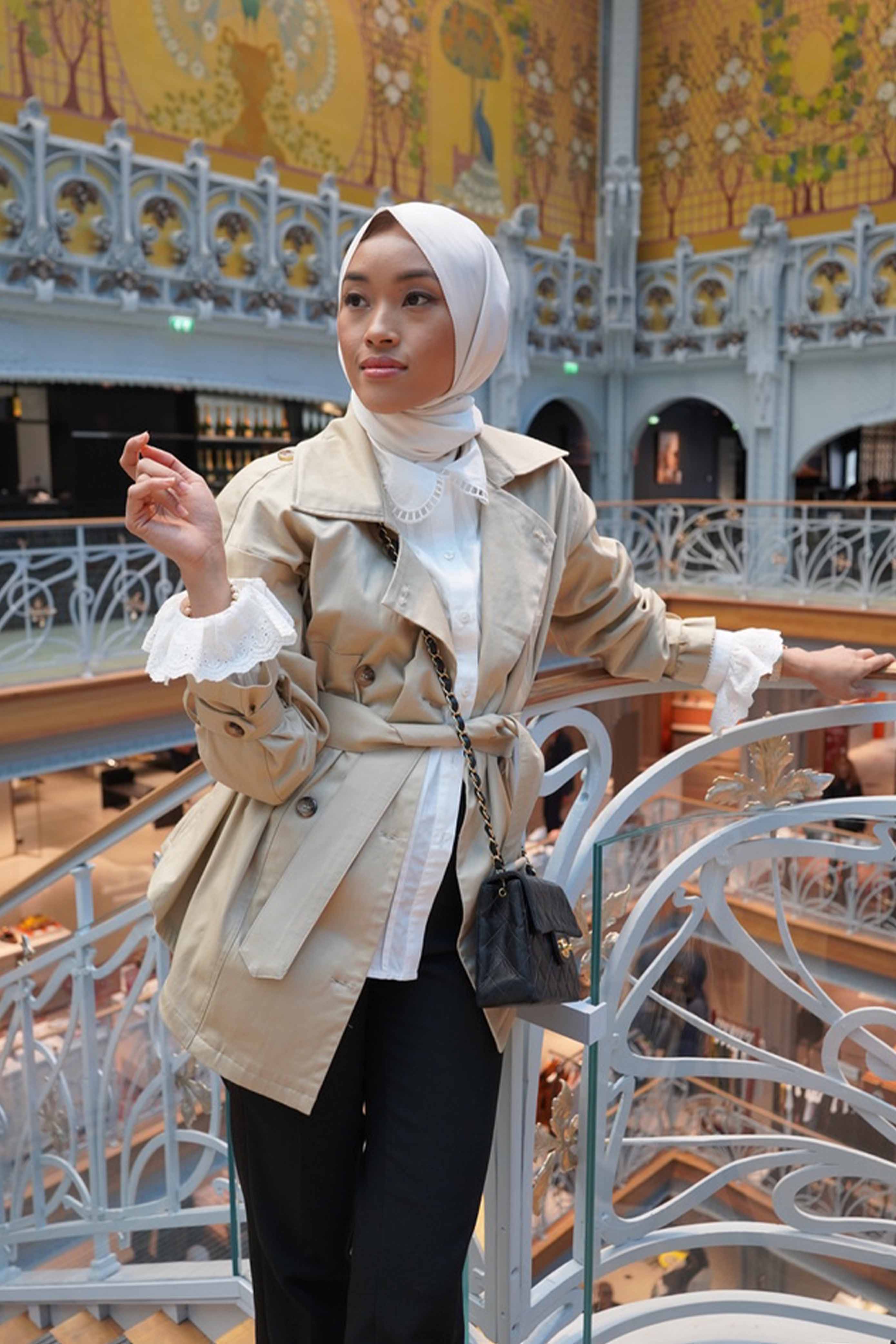 female model wearing a trench coat and posing for the camera