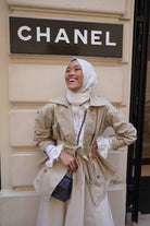 female model happily smiling in her new trench coat made by petit moi