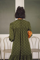 Closeup backshot of female model in high quality green polka dotted dress by petit moi